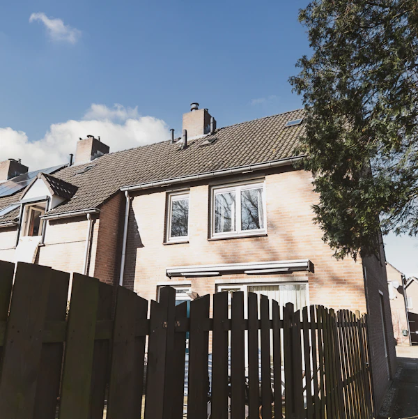 Wood fence in front of a home, an example of the surface fence painting protects