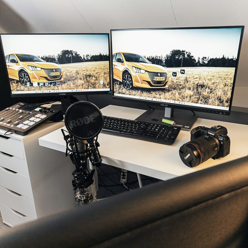 Due monitor di computer seduti sopra una scrivania