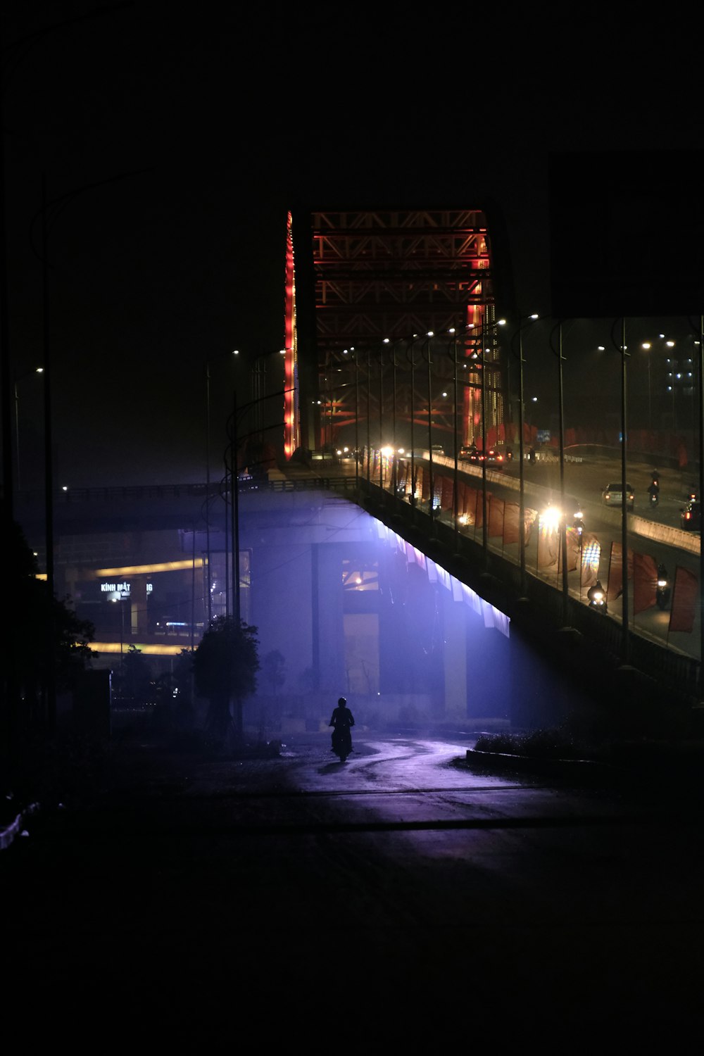 a person walking across a bridge at night