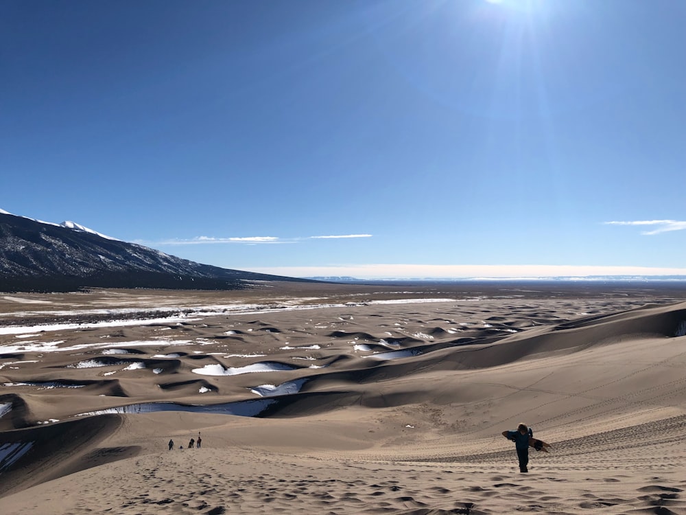 a person standing on top of a sand dune