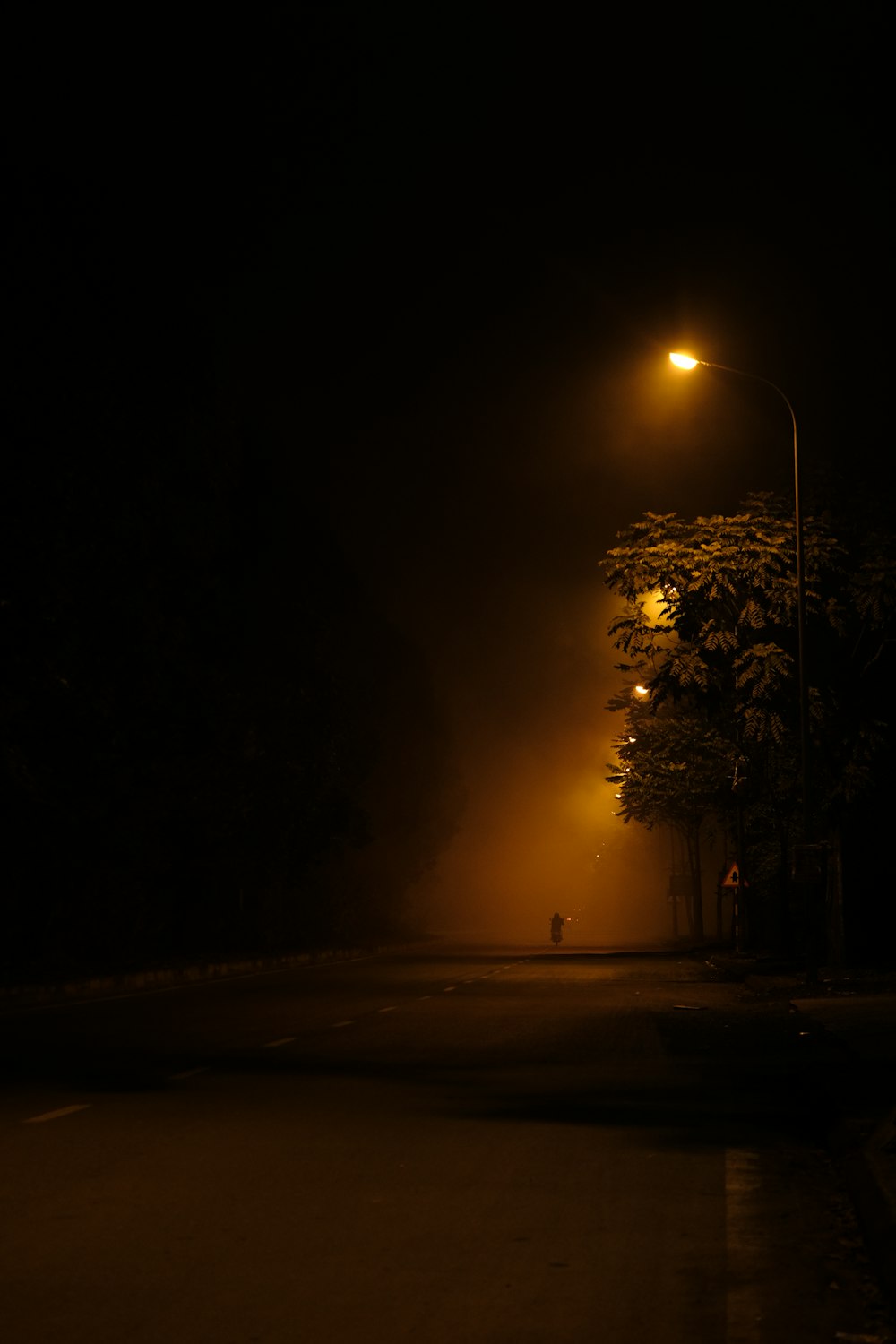 a street light shines on a dark street