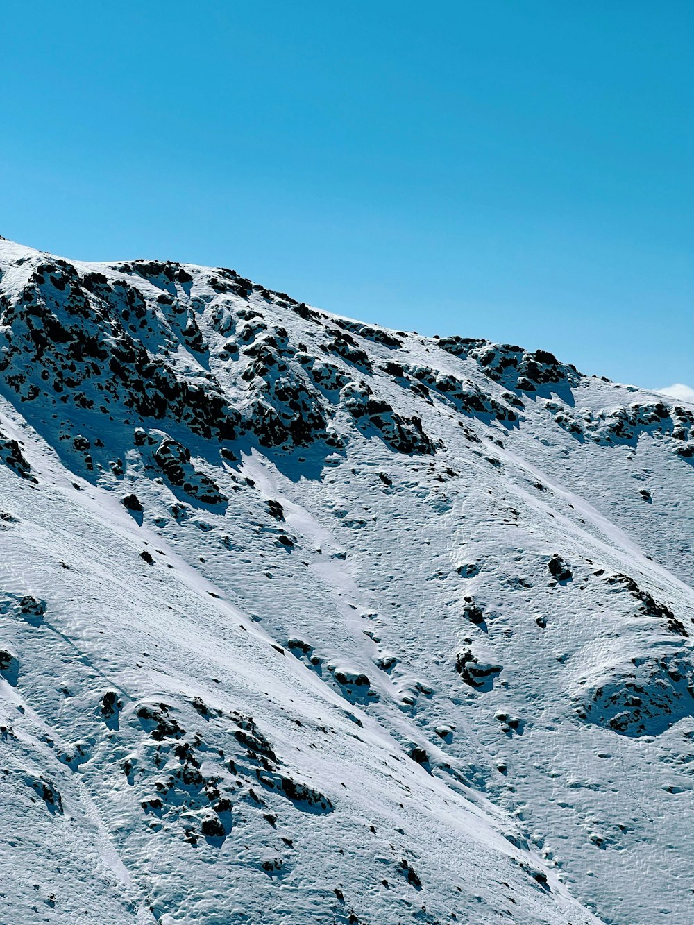 Ein Mann fährt mit Skiern die Seite einer schneebedeckten Piste hinunter