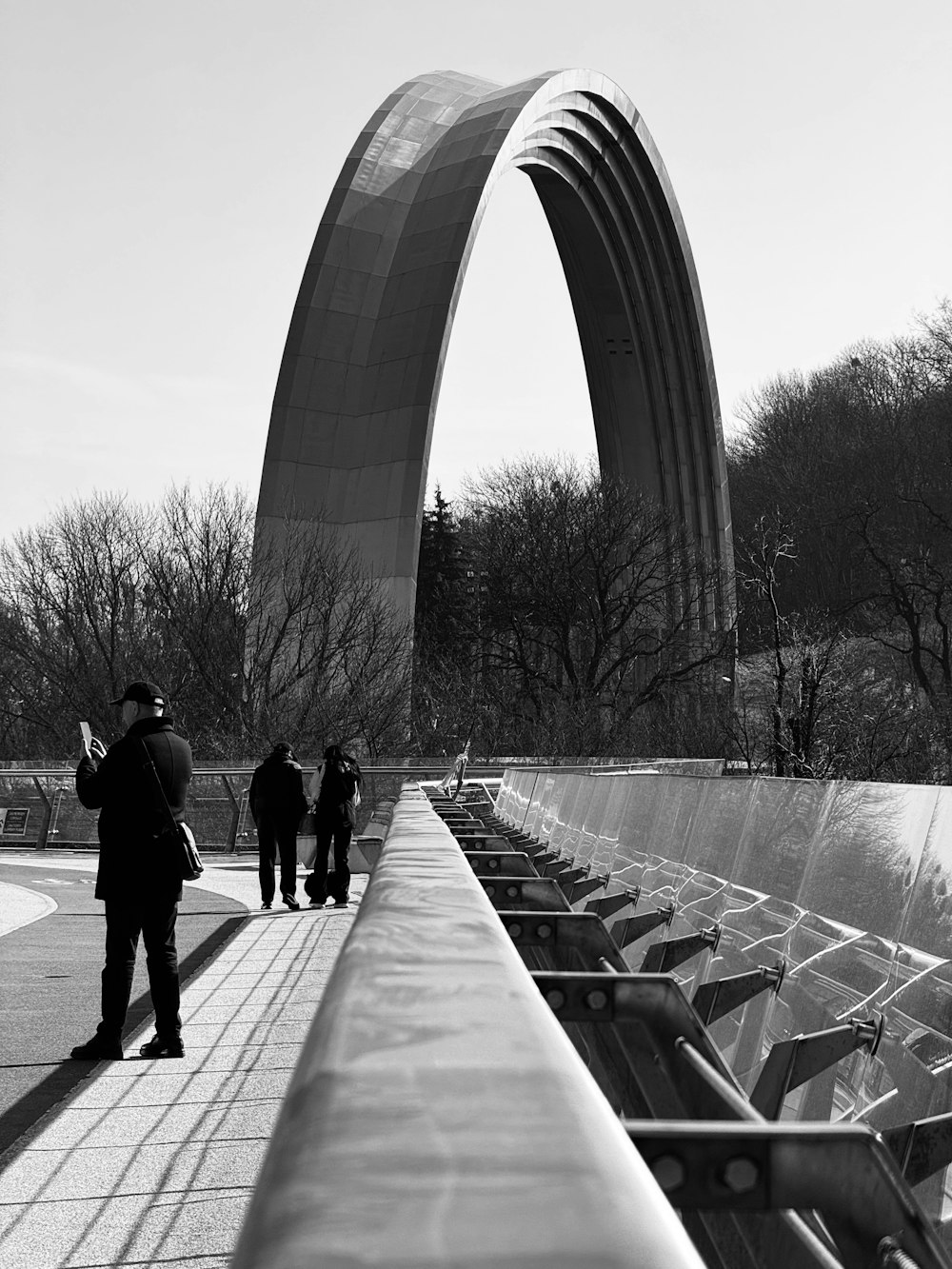 uma foto em preto e branco de pessoas caminhando em uma passarela