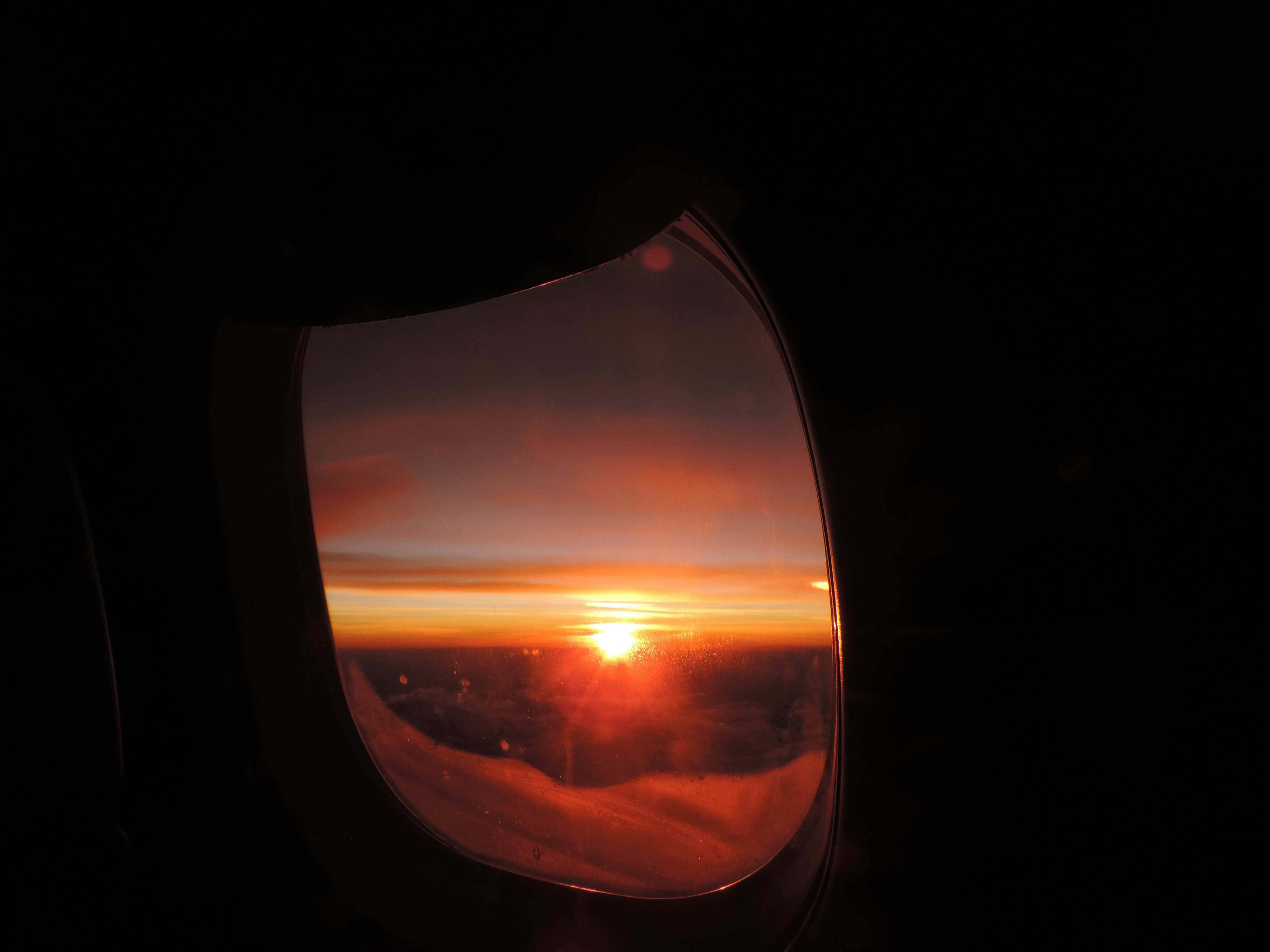 une vue d’un coucher de soleil à travers le hublot d’un avion