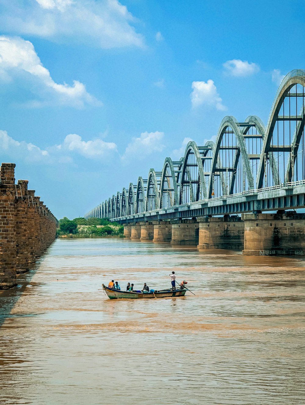 a small boat on a river with a bridge in the background