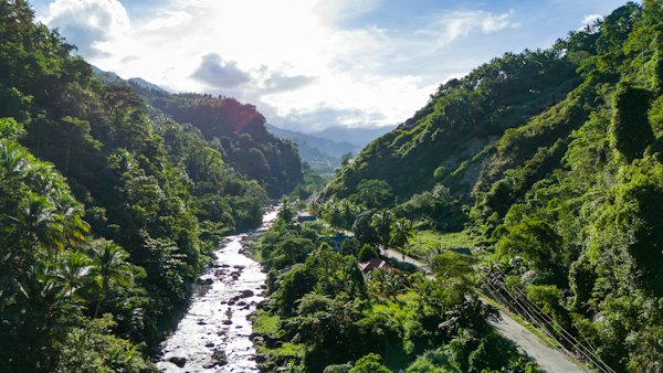 A river running through a lush green forest — Banaue & the rice terraces, Philippines