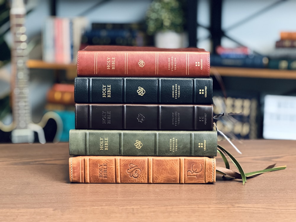 a stack of books sitting on top of a wooden table