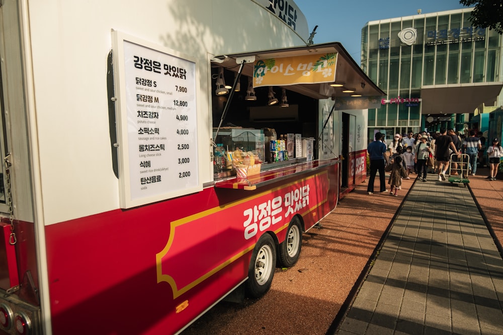 a red and white food truck parked in front of a building