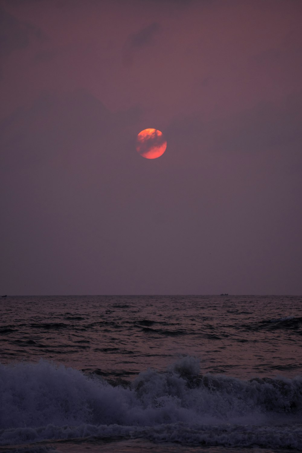 the sun is setting over the ocean with waves