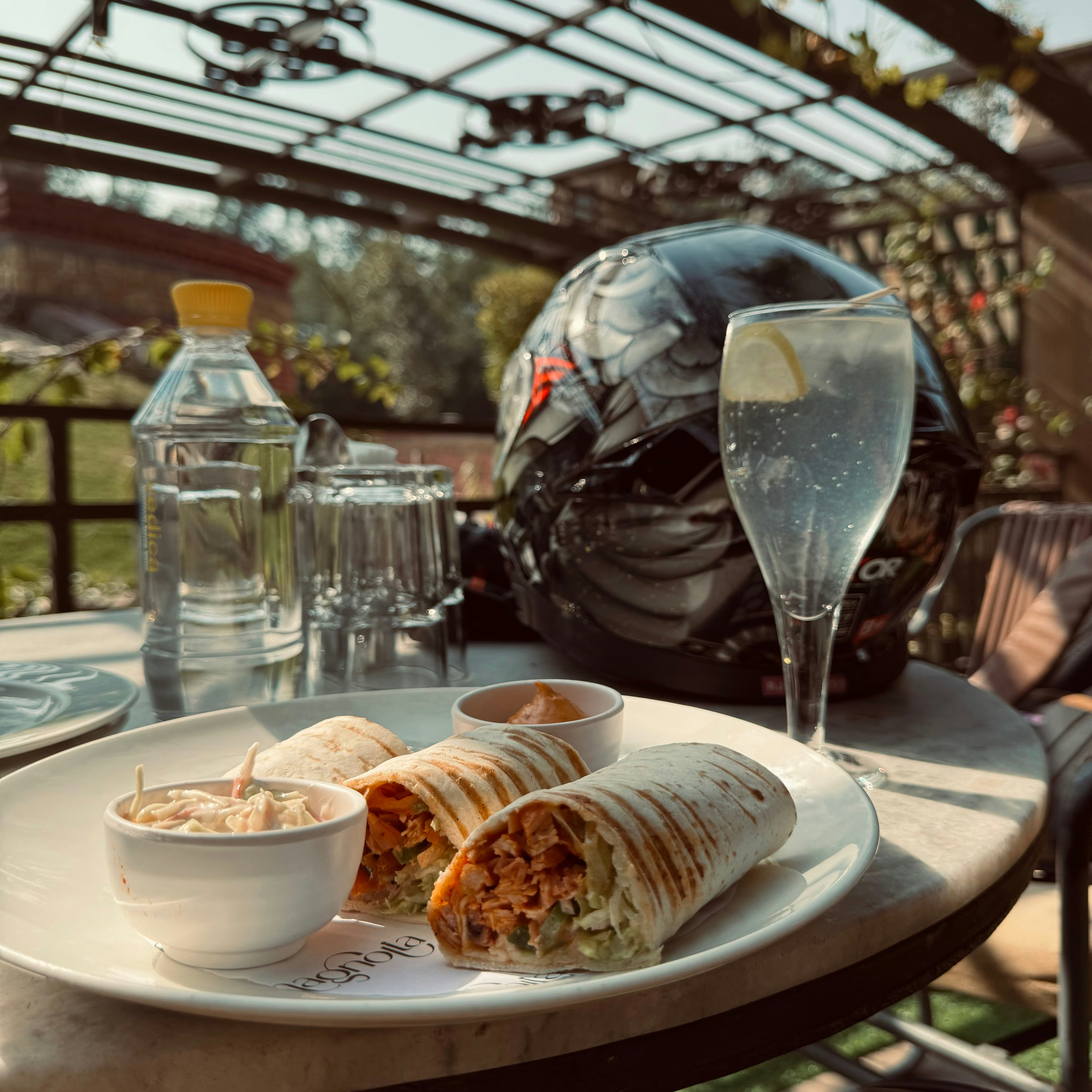 un plato blanco cubierto con un burrito y un tazón de salsa