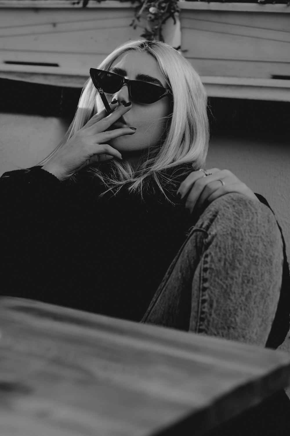 a woman sitting on a bench smoking a cigarette