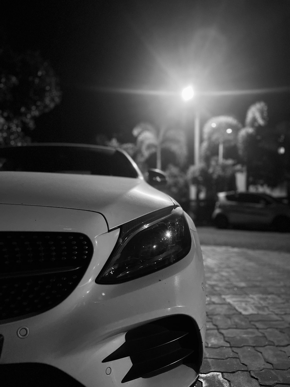 a white car parked on the side of a road at night