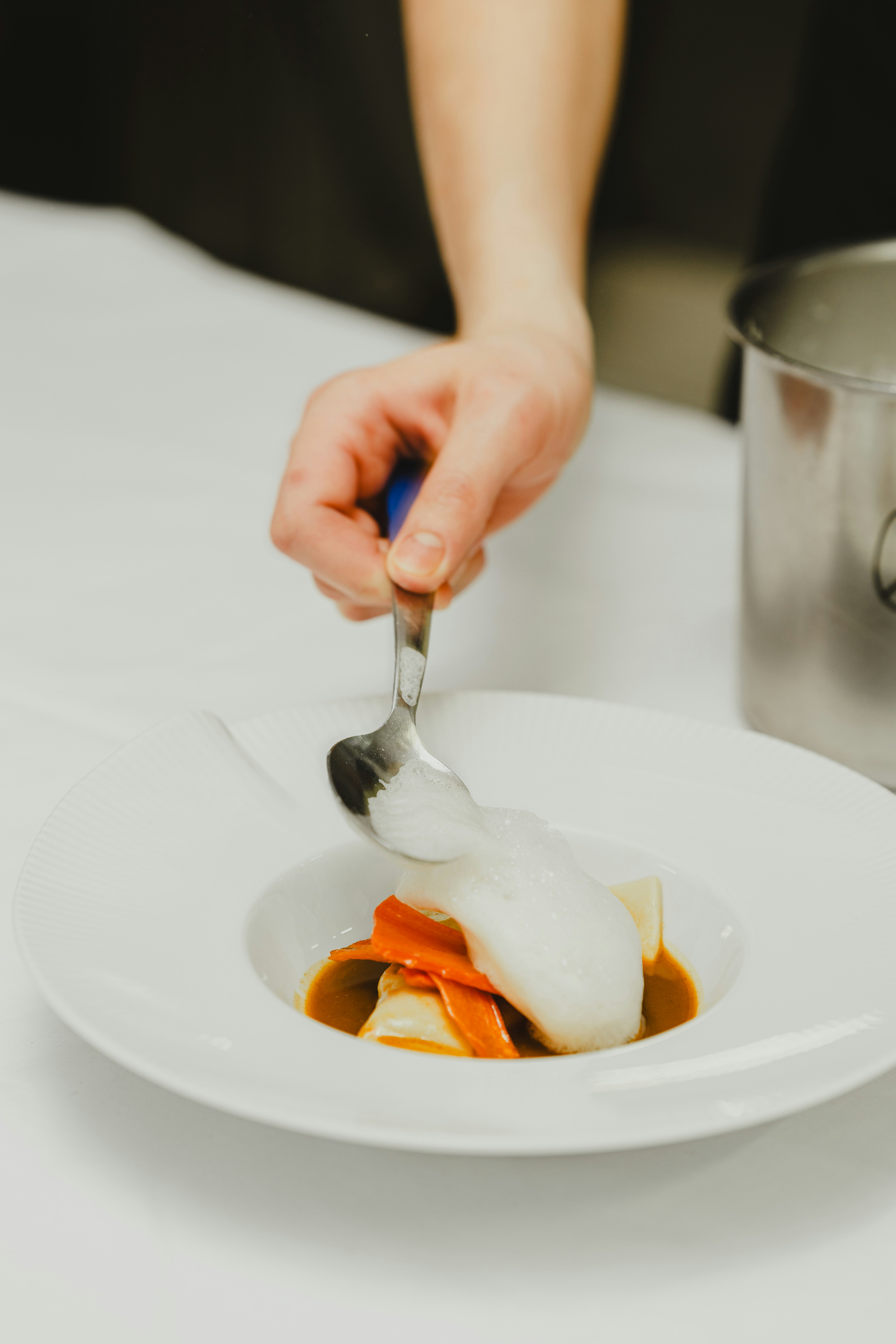a person with a spoon in a bowl of food