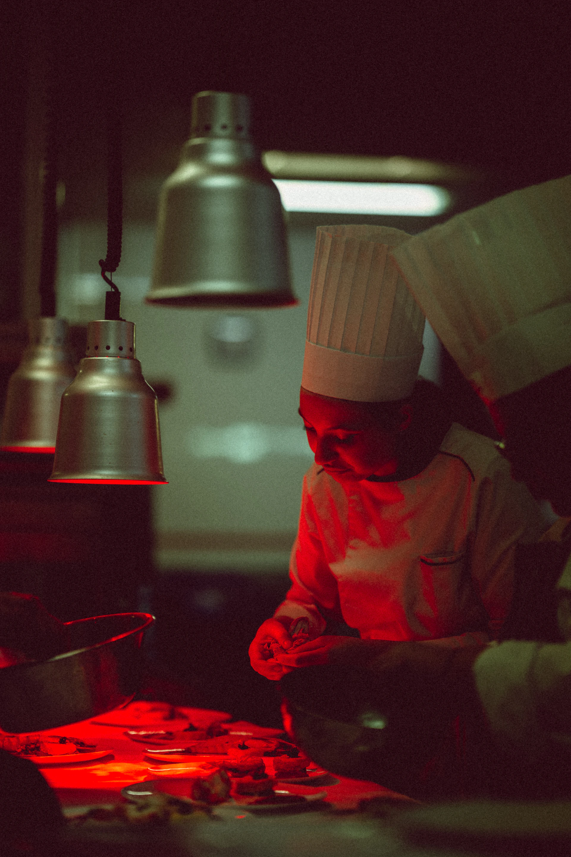 a chef preparing food in a kitchen at night