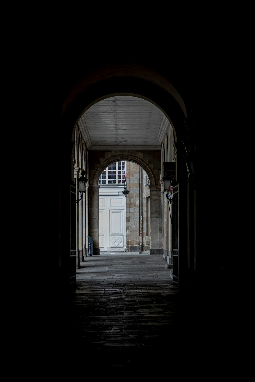 an archway leading into a building with a white door