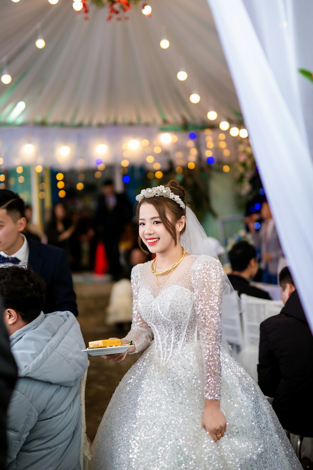 a woman in a wedding dress holding a plate of food