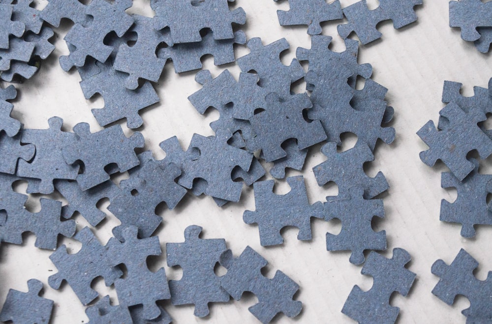 a pile of blue puzzle pieces on top of a table