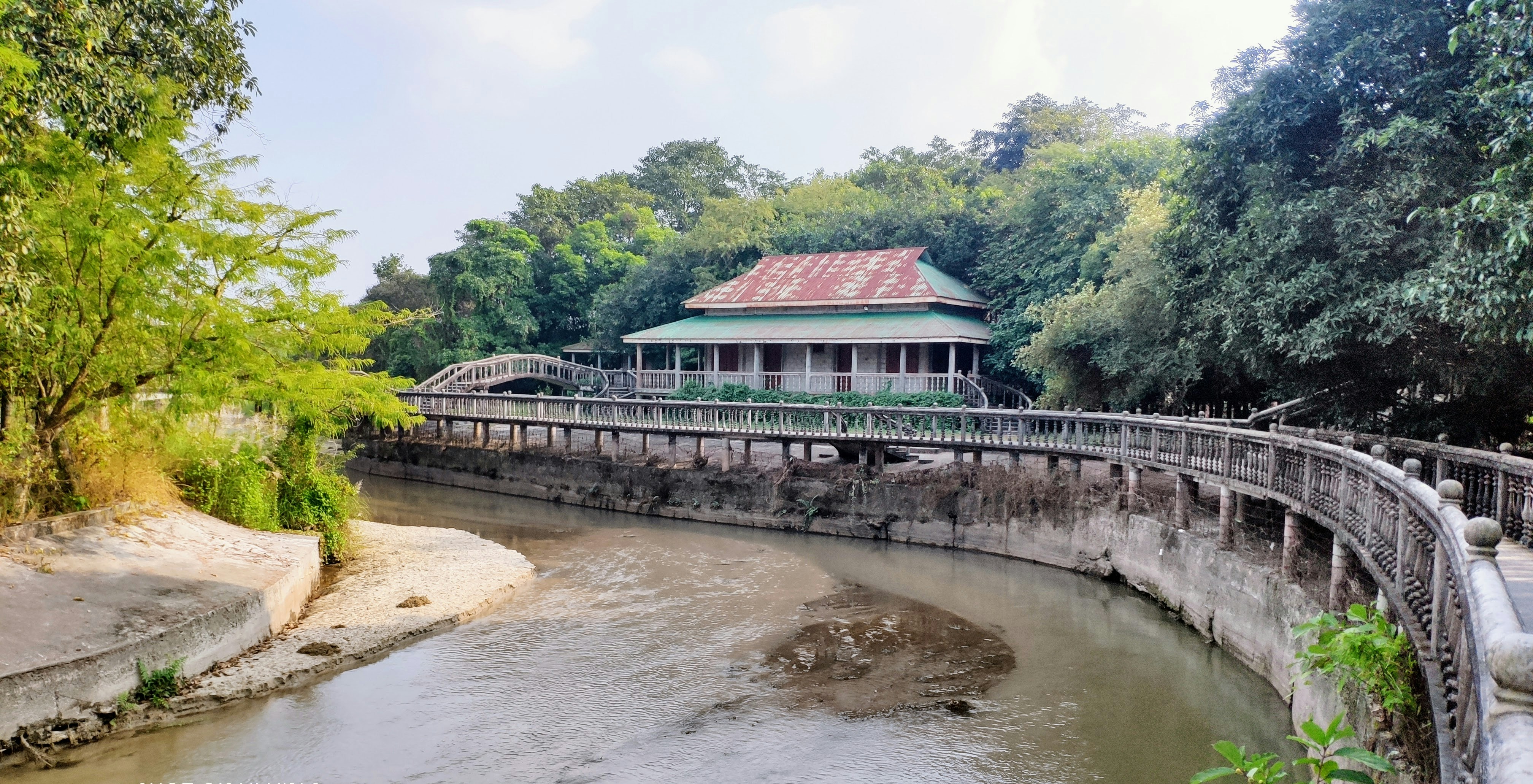 a building sitting on top of a bridge next to a river