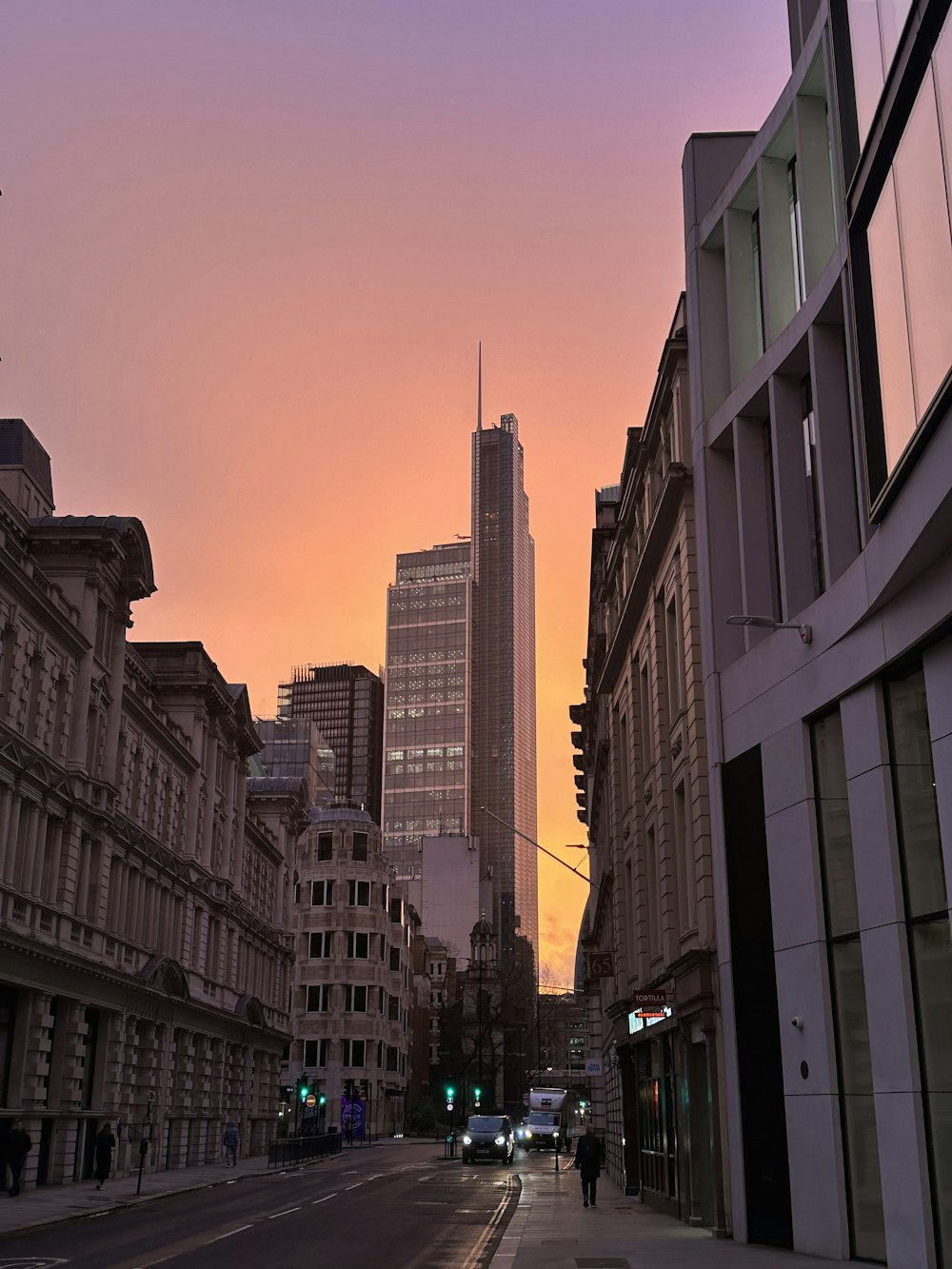 a city street with tall buildings in the background