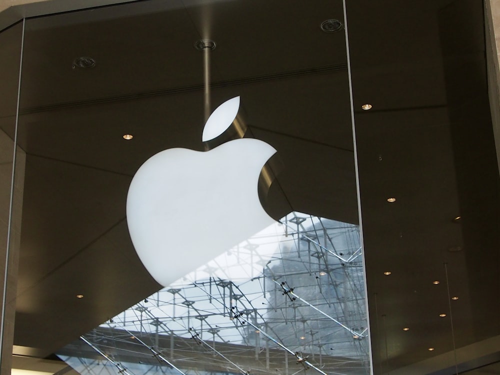 the apple logo is reflected in the glass