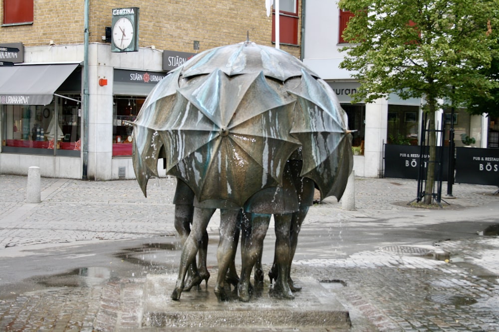 a statue of two horses with an umbrella on their back