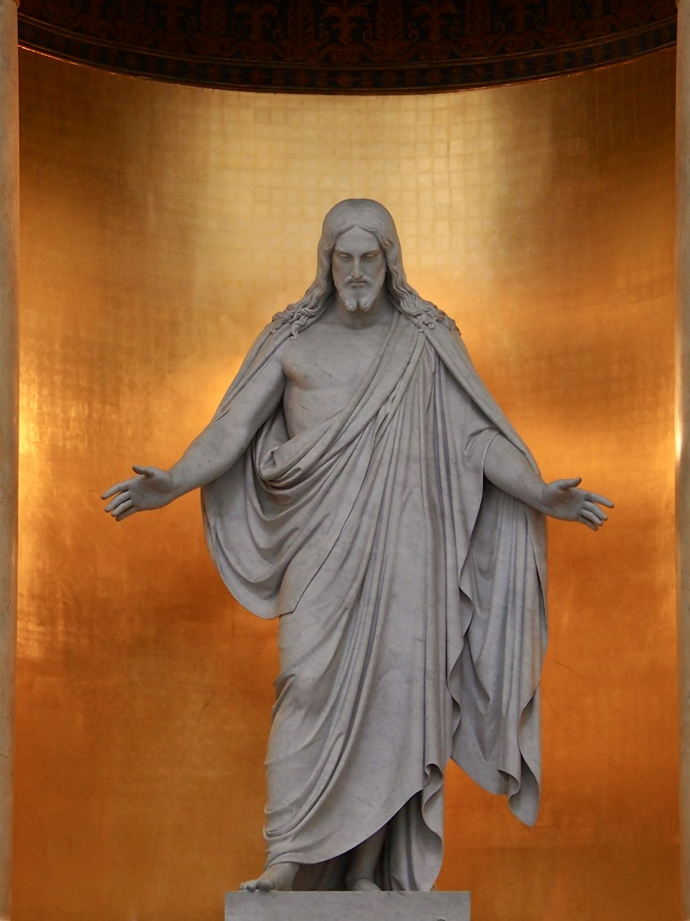 a statue of jesus in a golden room