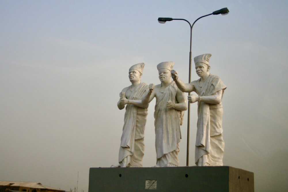 隣り合って立っている男性の彫像のグループ