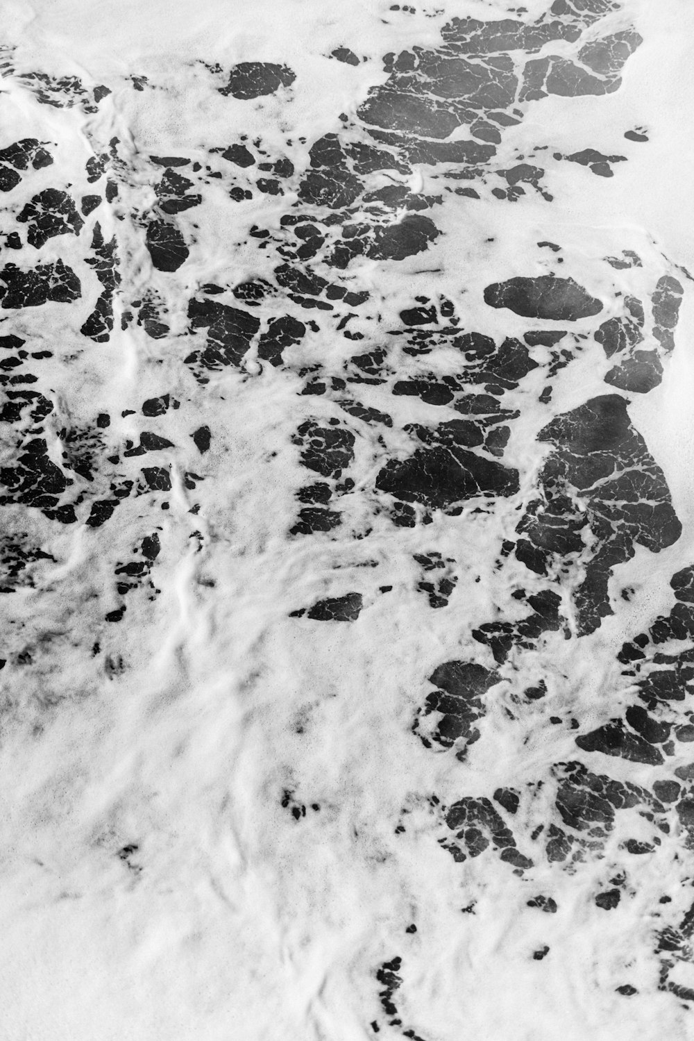 a black and white photo of water and rocks