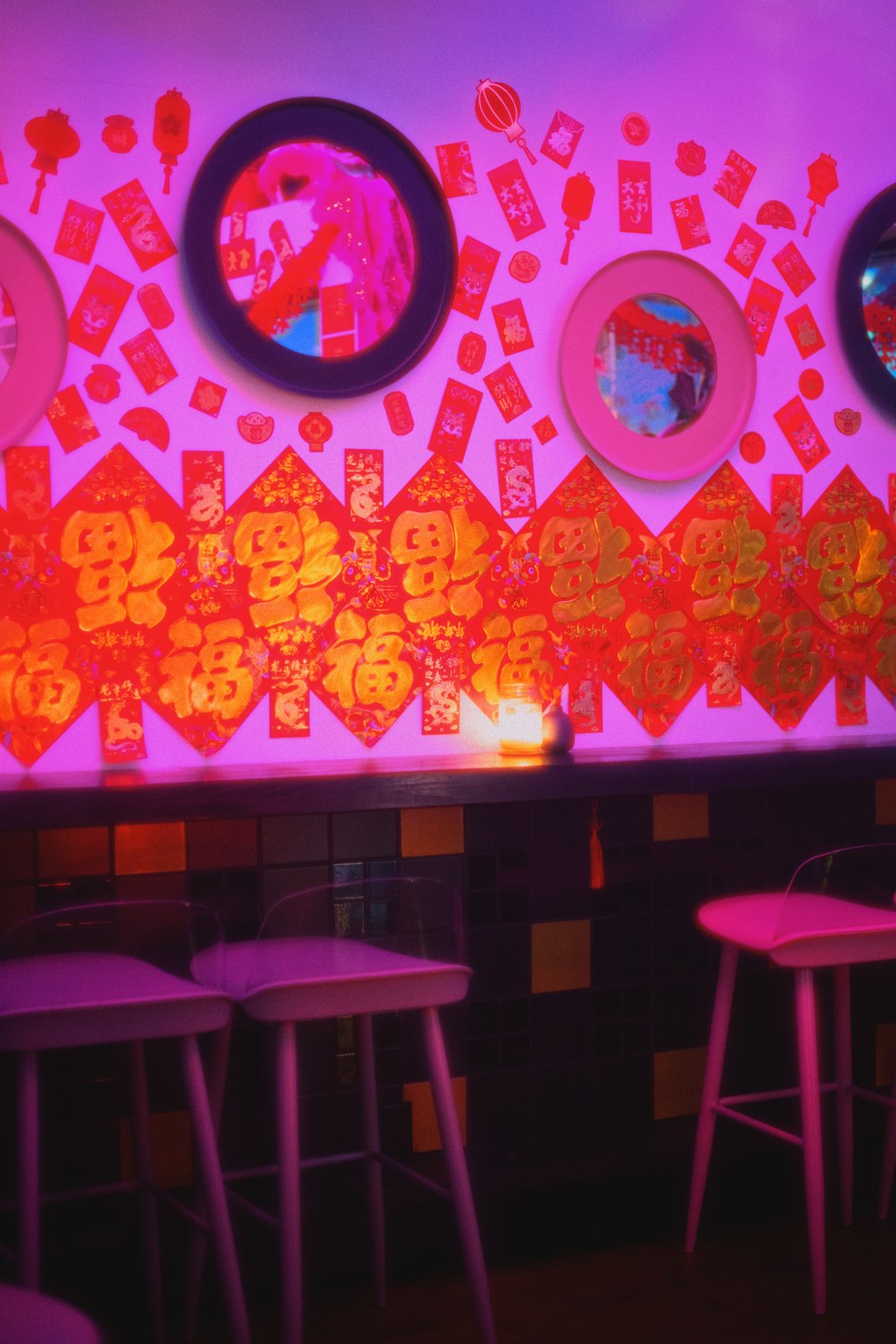 a bar with a neon colored wall and neon colored stools