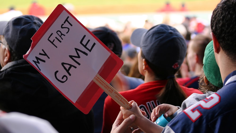 a person holding a sign that says my first game