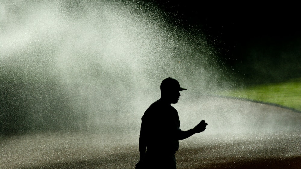 a man standing in front of a sprinkle of water