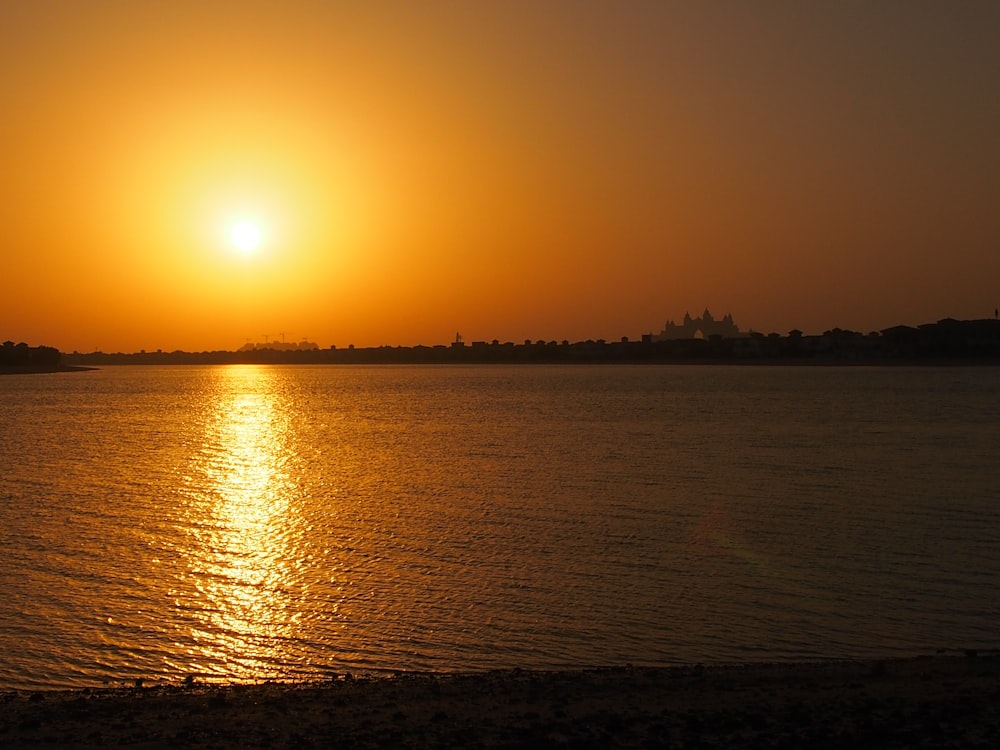 the sun is setting over a body of water