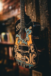 a guitar hanging from the side of a wall