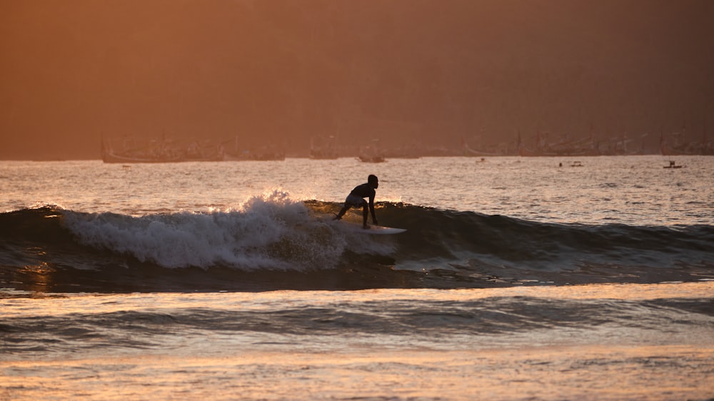 a man riding a wave on top of a surfboard