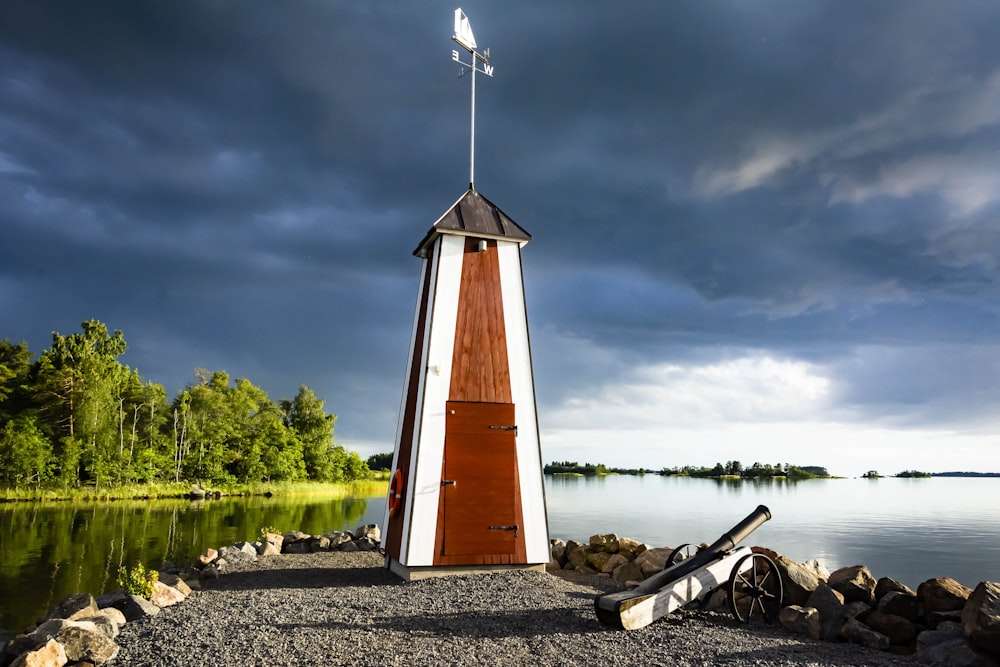 una torre di legno seduta in cima a una spiaggia vicino a uno specchio d'acqua