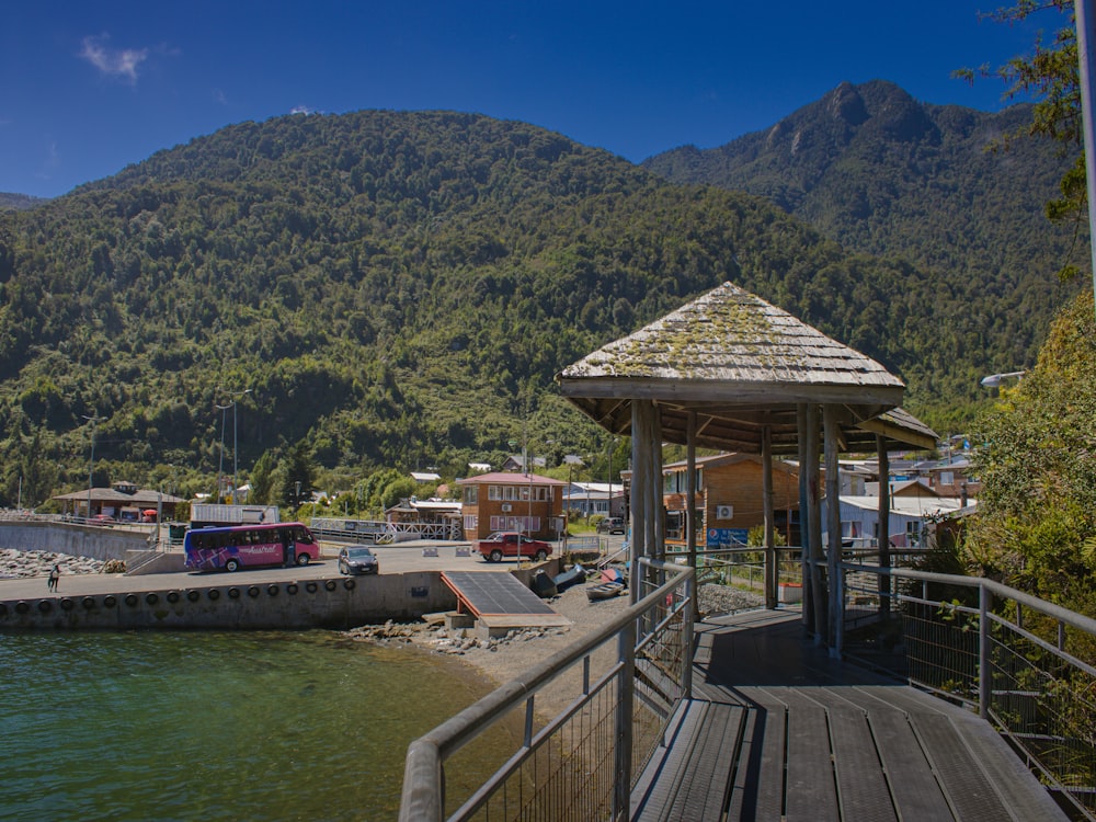 a gazebo sitting on a pier next to a body of water