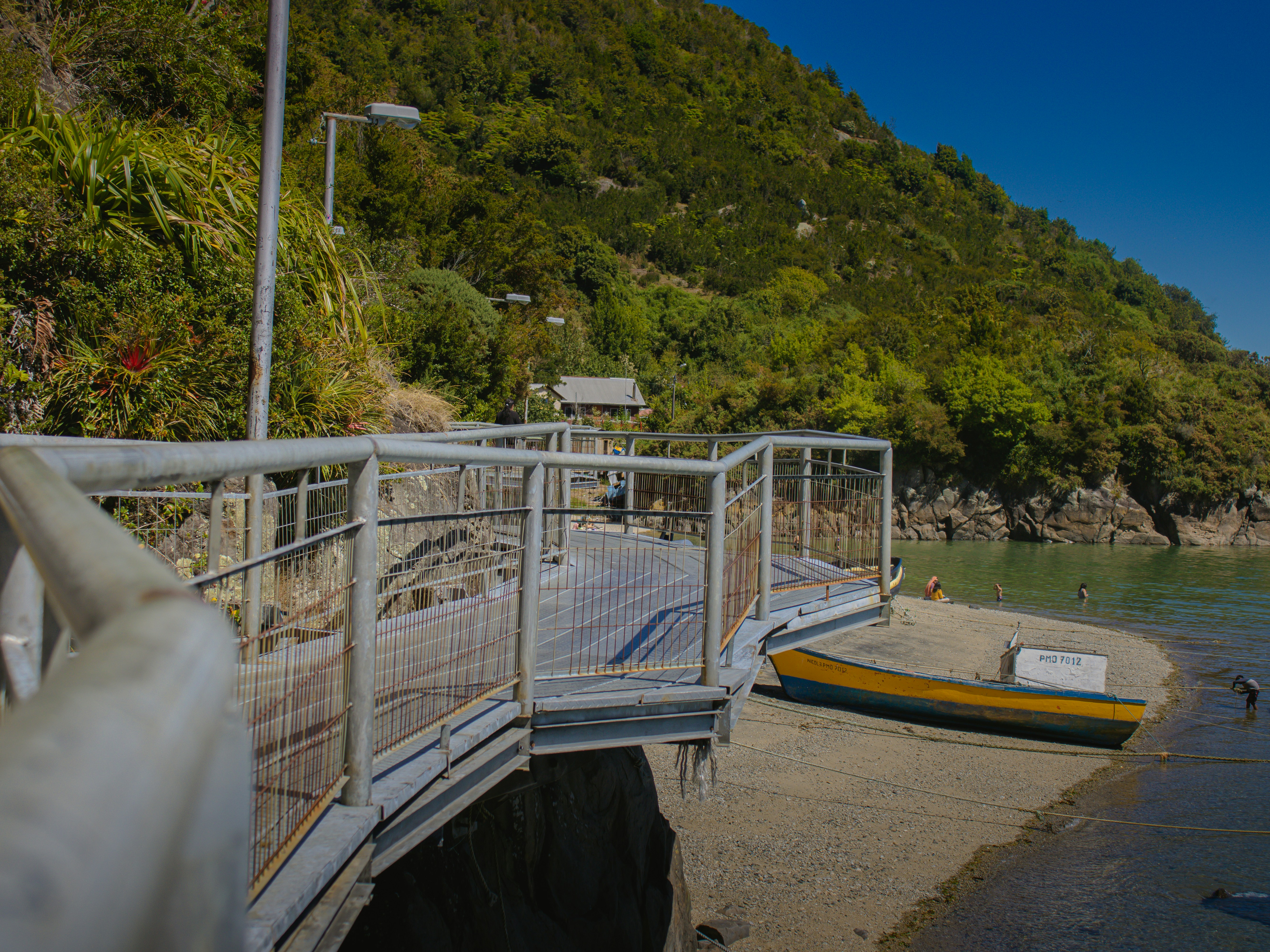 a boat sitting on top of a beach next to a bridge