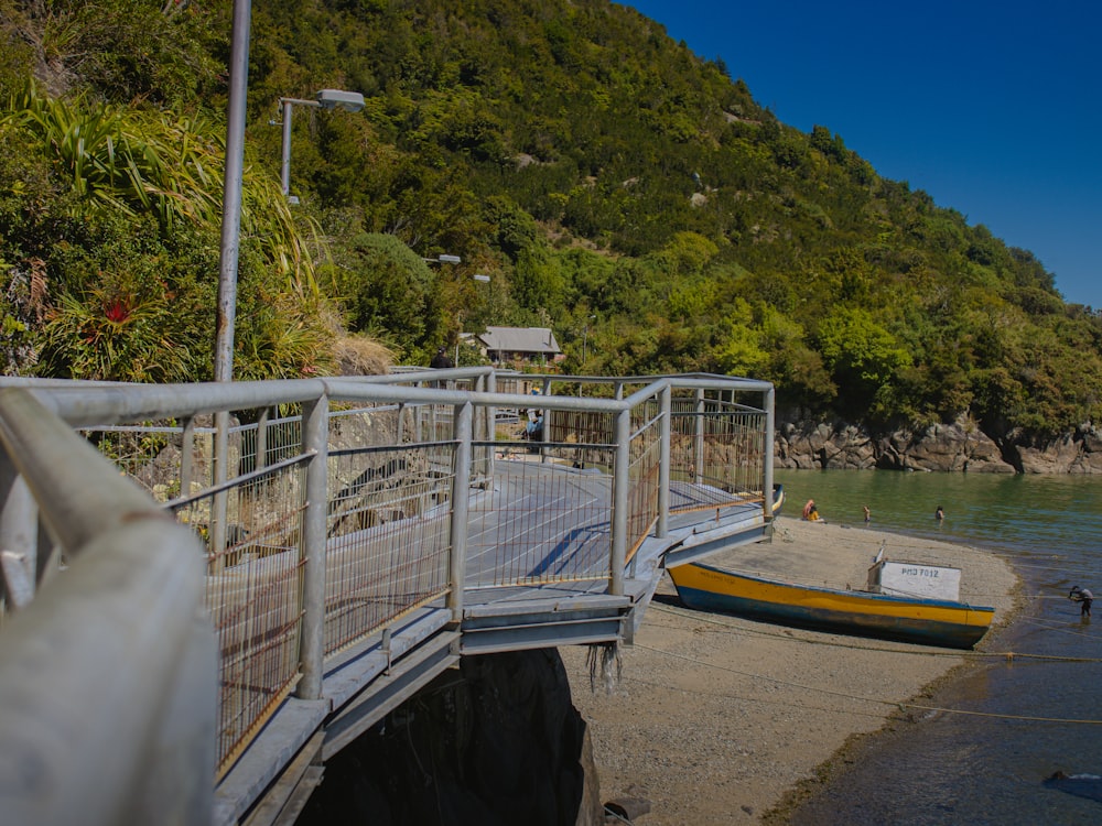 a boat sitting on top of a beach next to a bridge