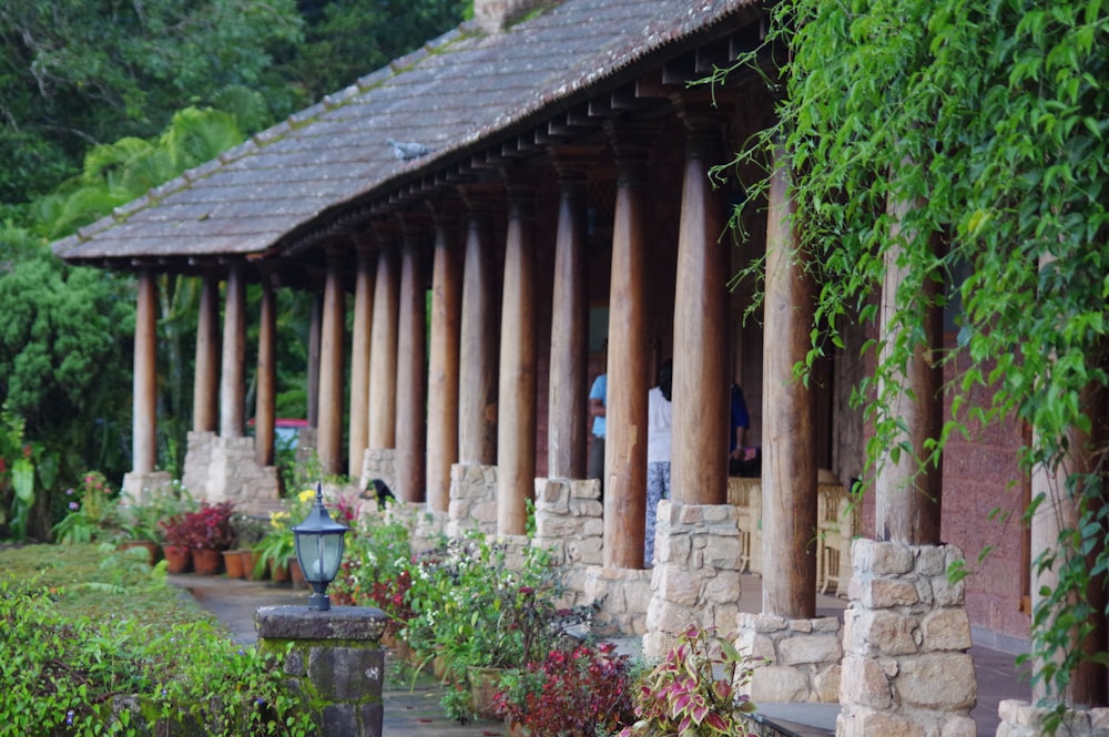 a row of wooden pillars next to a lush green forest