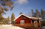 a red house with a porch and a wooden fence
