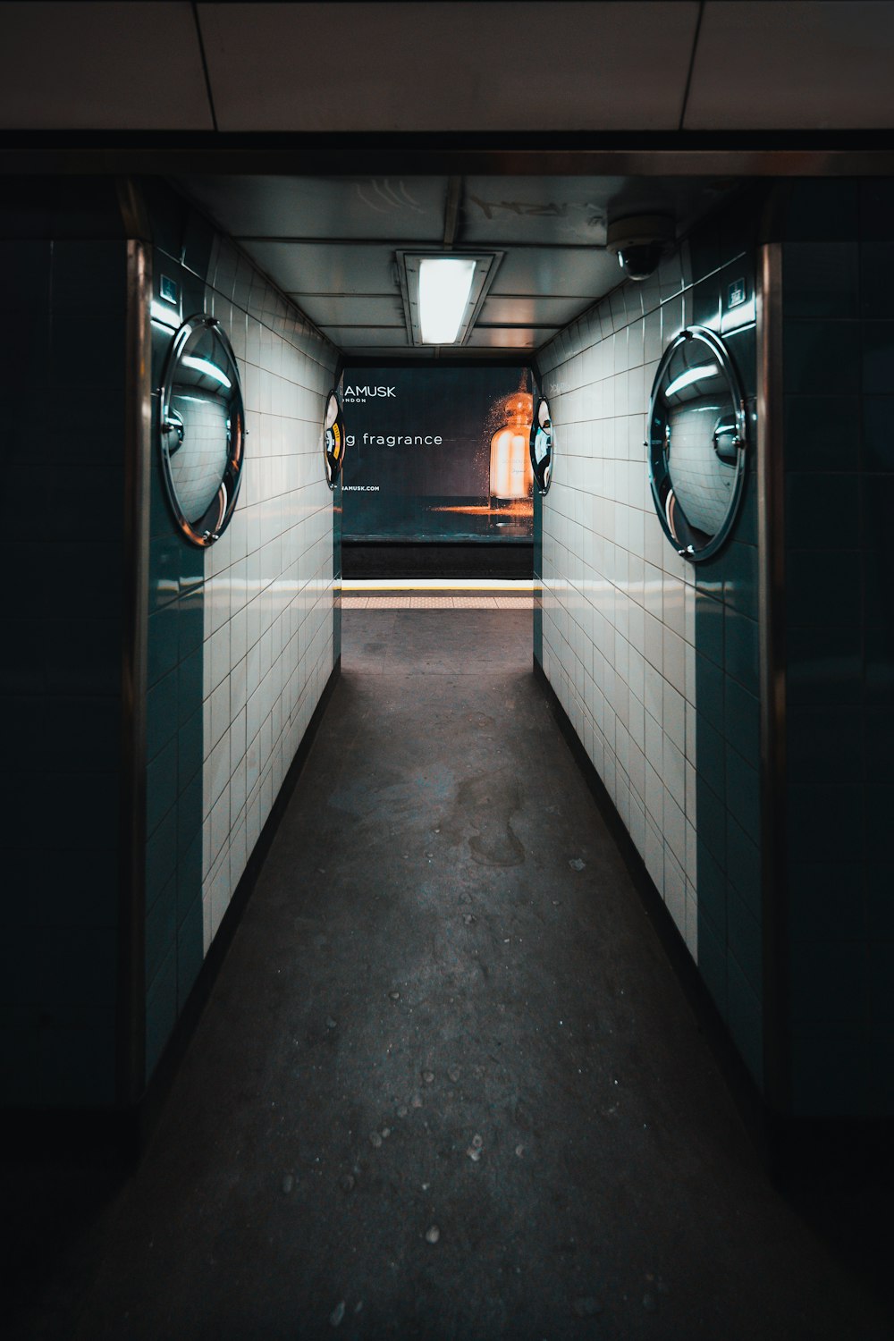 a long narrow hallway with two circular mirrors on the wall