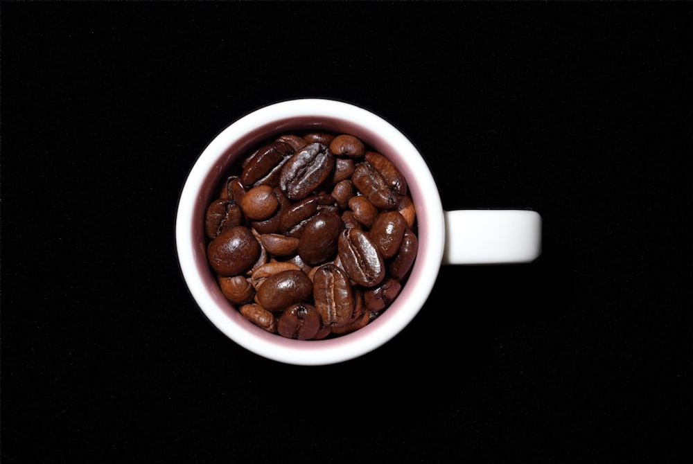 a cup of coffee beans on a black background