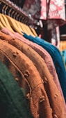 a row of clothes hanging on a rack in a store
