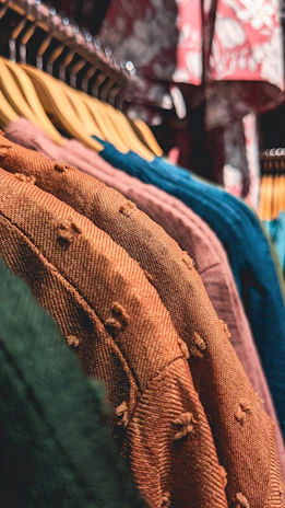 a row of clothes hanging on a rack in a store