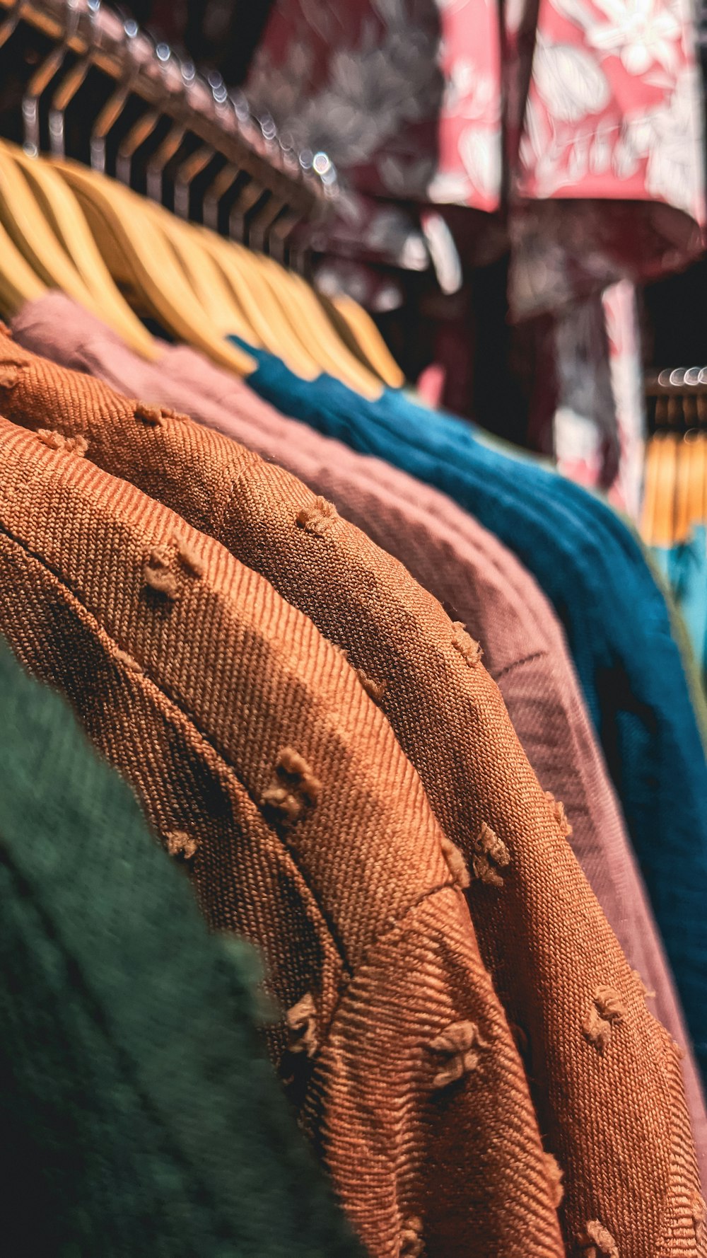 una fila di vestiti appesi su uno scaffale in un negozio