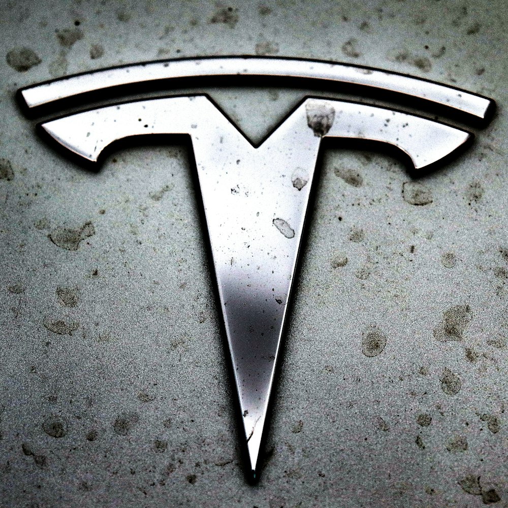 Un primer plano de un logotipo de Tesla en un automóvil