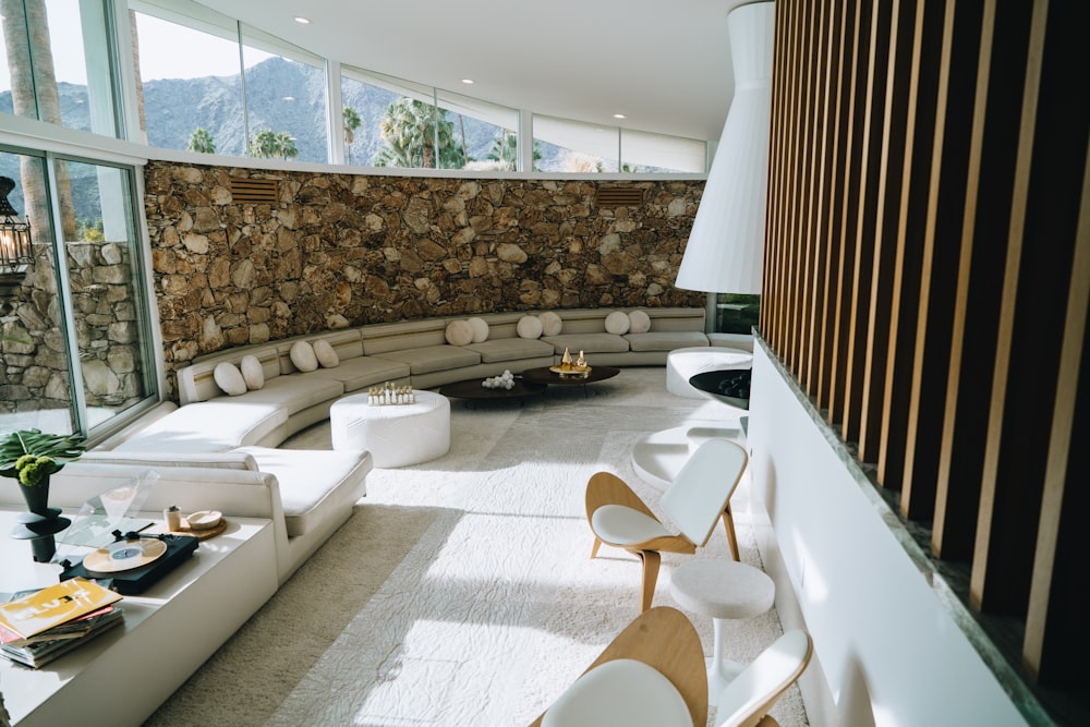 a living room filled with furniture and a stone wall