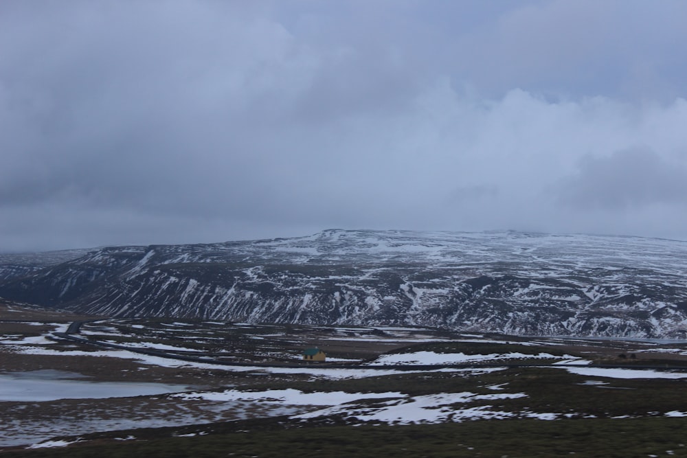 a mountain covered in snow with a cloudy sky