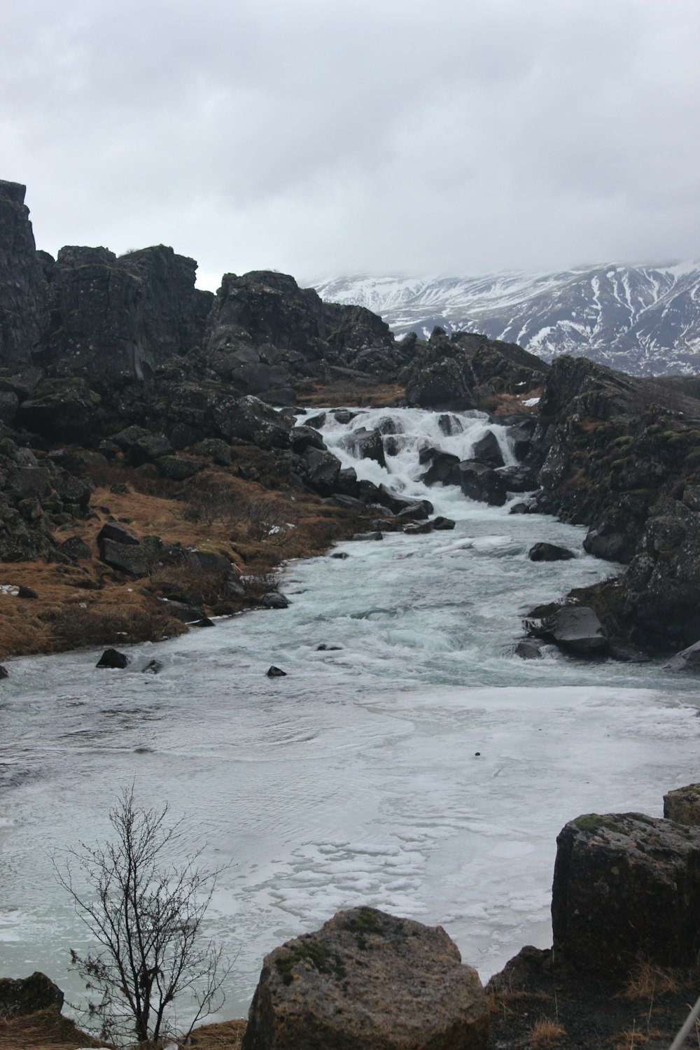 a body of water surrounded by rocks and snow