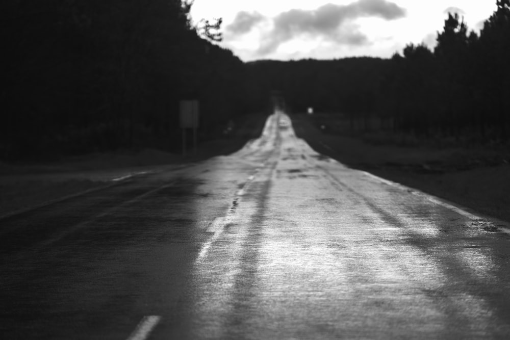 a black and white photo of a wet road